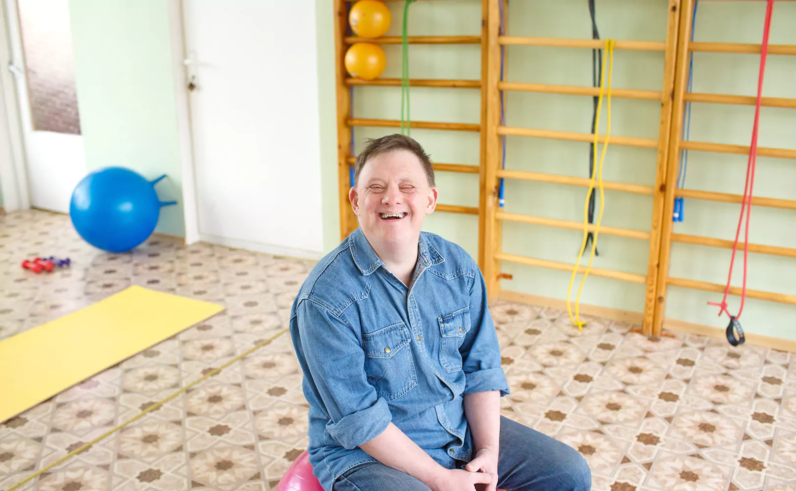 A disabled man smiling while sitting down